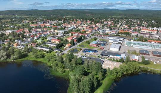 Vy över en stad med sjöar, gröna områden och byggnader i olika färger.