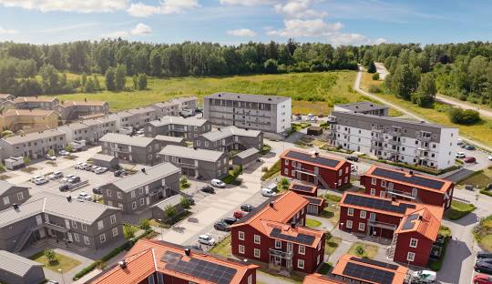 Nybyggd bostadsområde med moderna hus och gröna omgivningar.