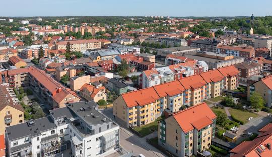 Vy över stadsdelen med byggnader och tak i olika färger under klar himmel.