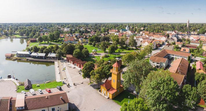 Utsikt över en Östhammar vid vatten, med gröna parker och traditionell arkitektur.