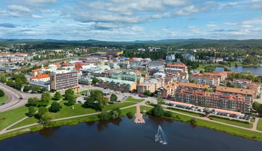 Utsikt över en stad vid vatten, med byggnader och grönområden.
